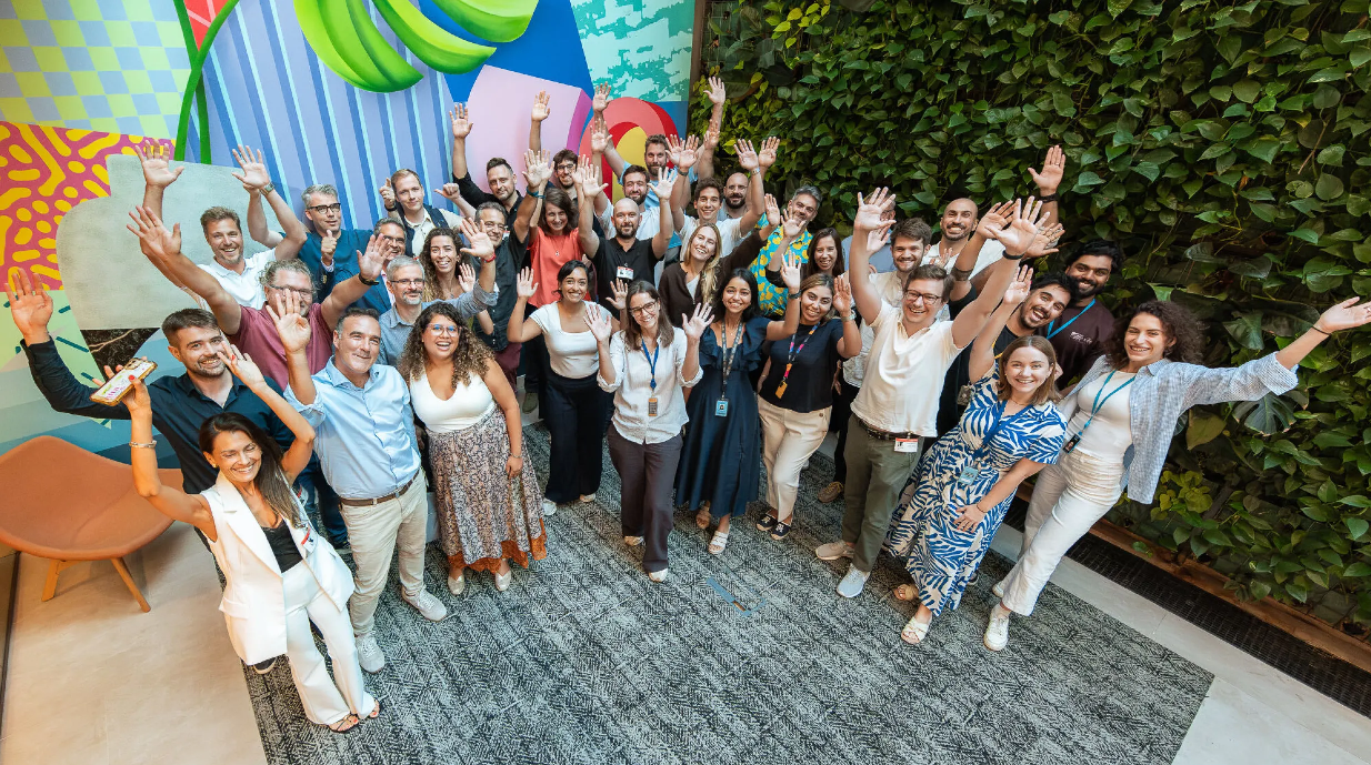 A large group of people smile and cheer for a photo. 