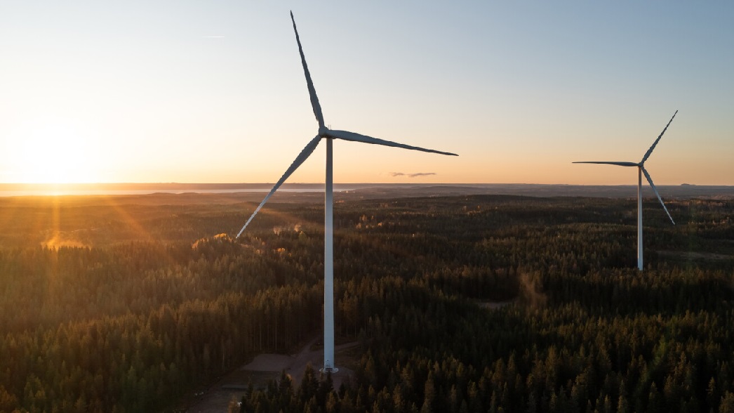 Wind turbines with a sunset in the distance. 