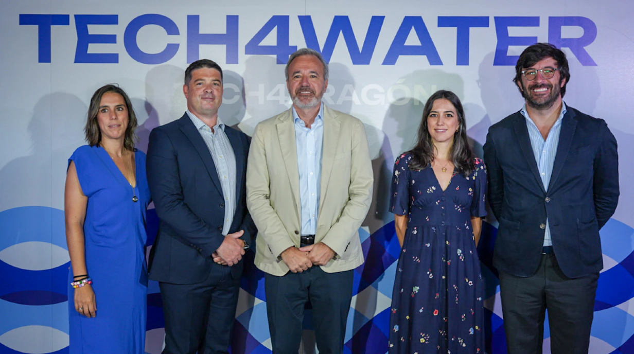 Five people stand for a photo in front of a background that says "TECH4WATER." 