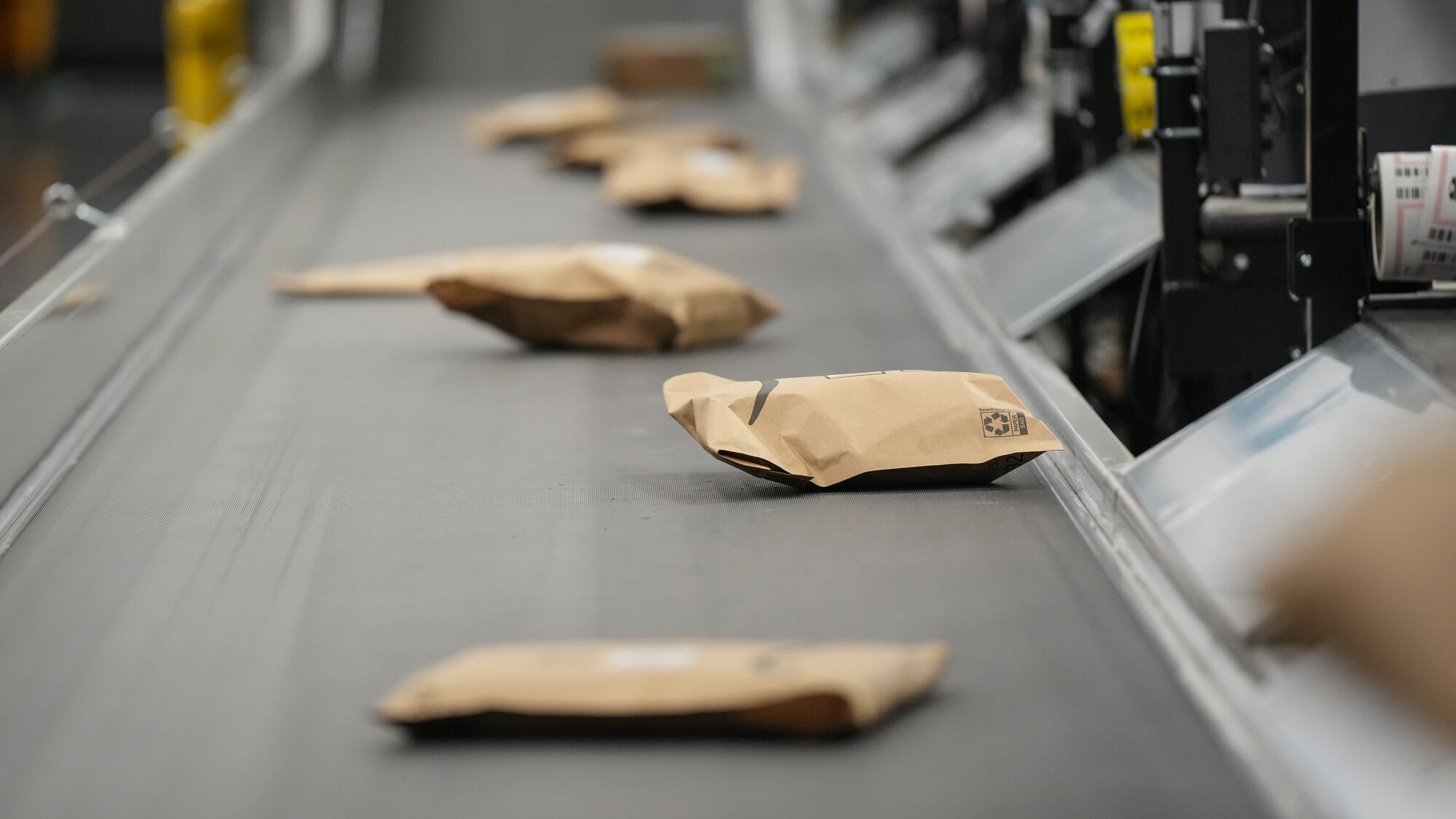 Paper mailers on a conveyor belt.