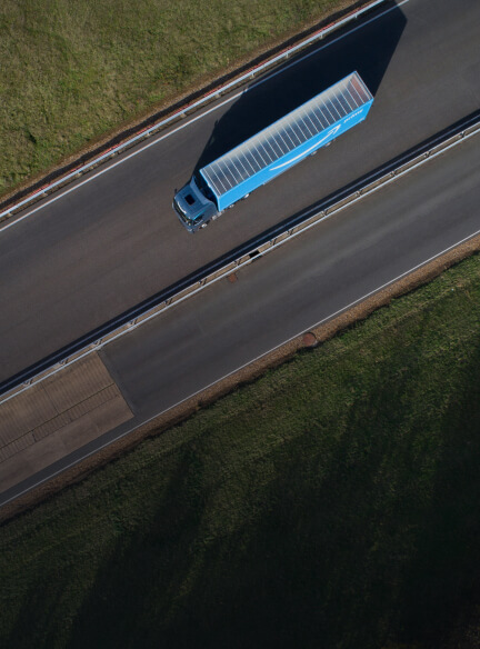 A long-haul Amazon truck is shown from above driving down a road above text that says "Renewable diesel." 