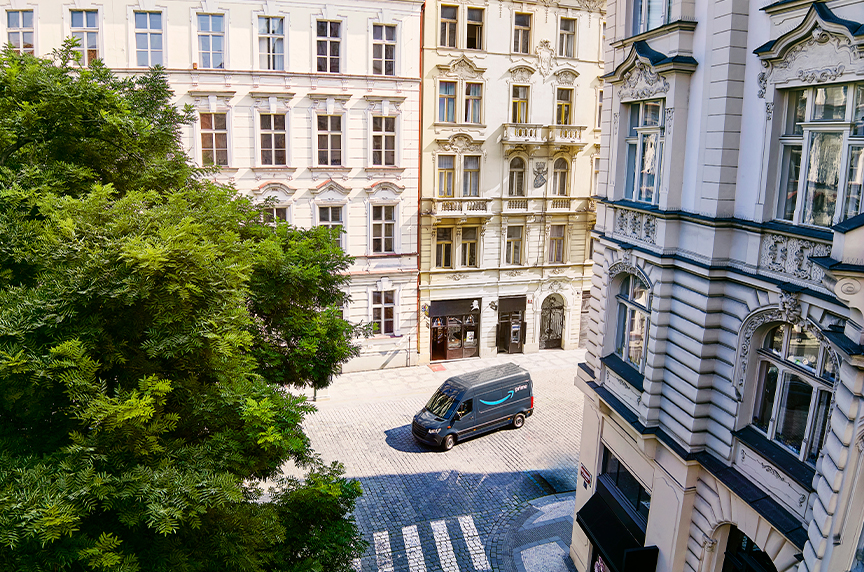 An electric Amazon van drives through European streets. 
