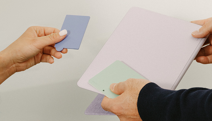 Hands holding up samples of fabric materials.