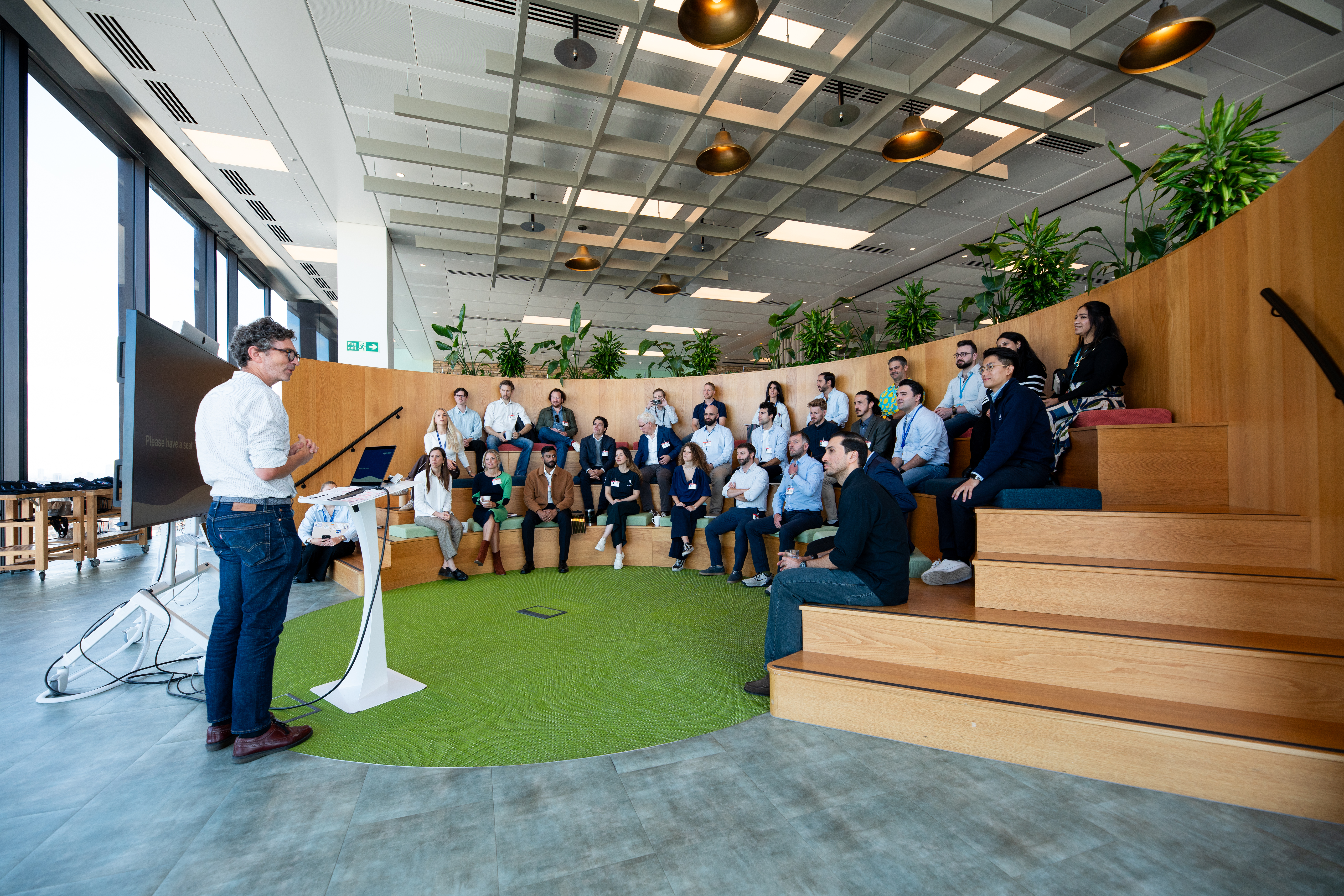 A person at a podium speaks to a group of people. 