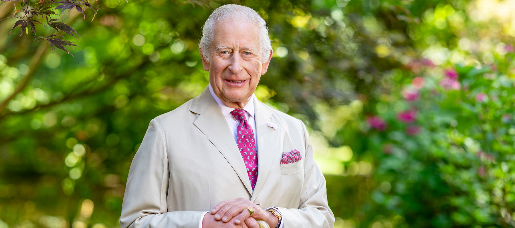 Person smiling surrounded by greenery. 
