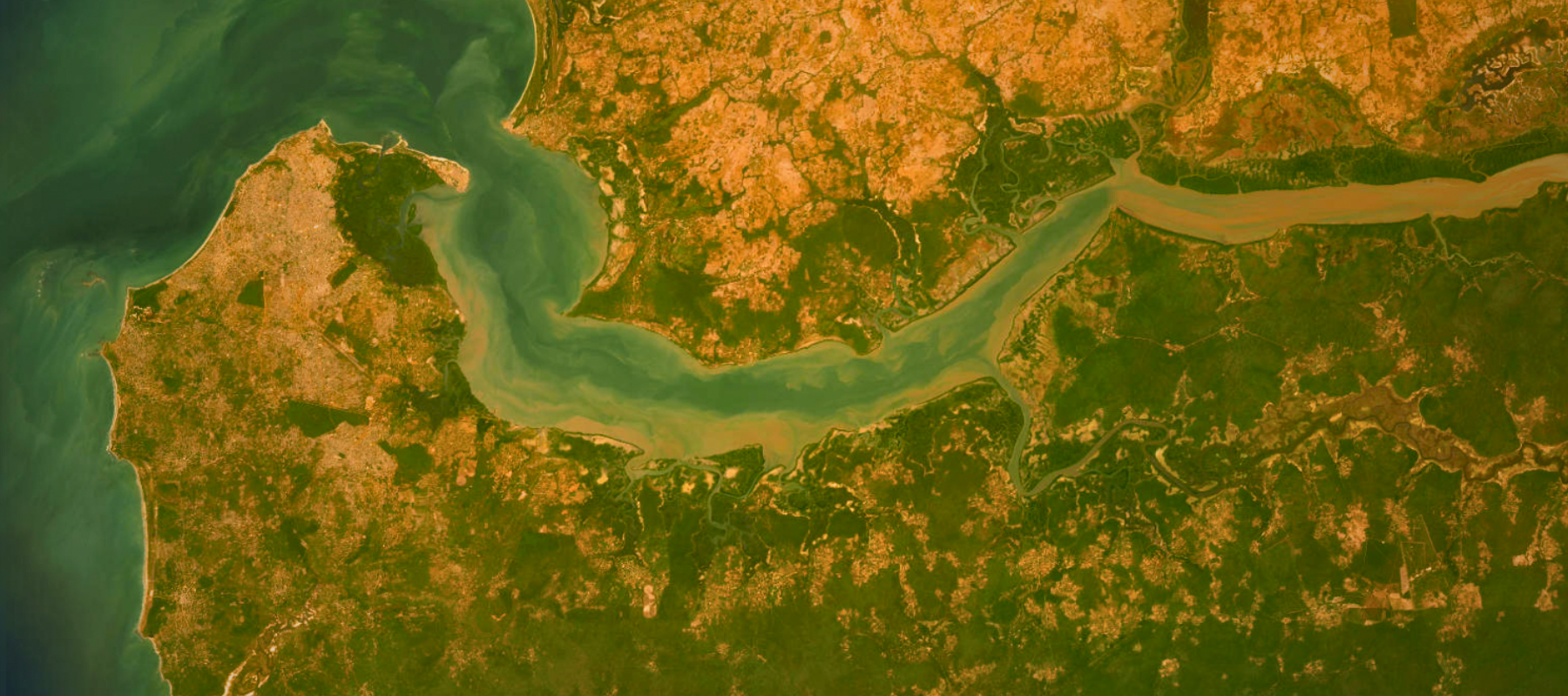 A bird's-eye view of a dry landscape surrounded by water. 